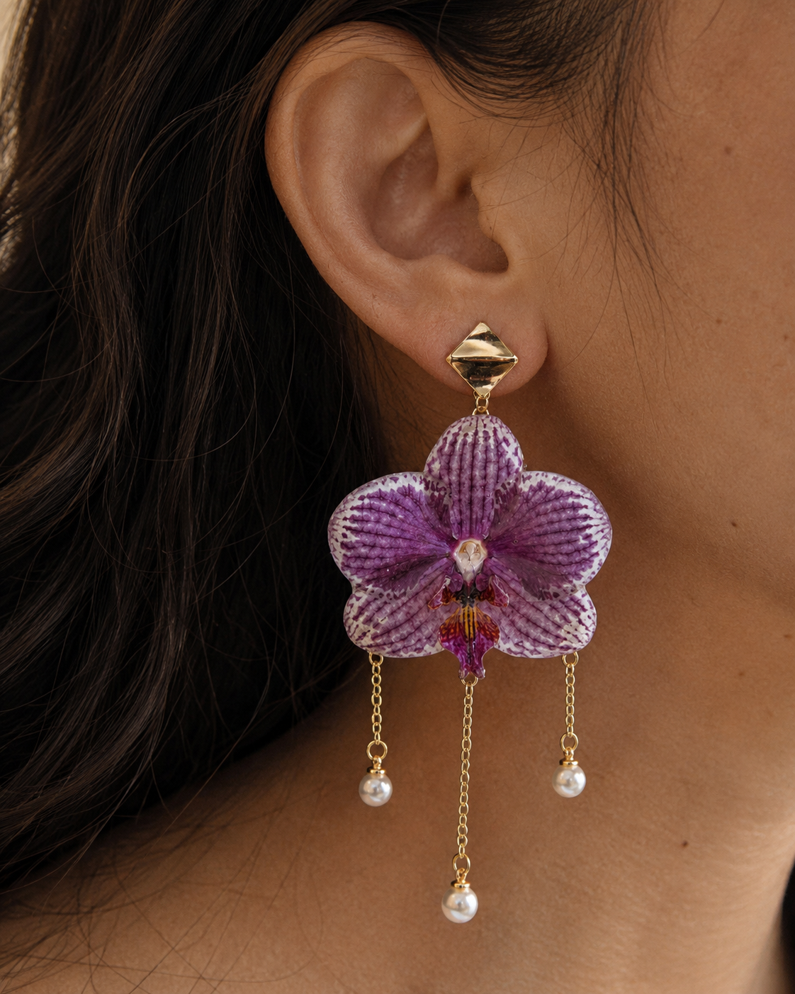 Model wearing purple orchid pearl drop earrings with three delicate chain drops, Purple Orchid Pearl Drop Earrings botanical jewellery by Terra Decode
