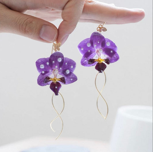 Purple orchid earrings with resin petals and fine gold-tone tassel details by Terra Decode