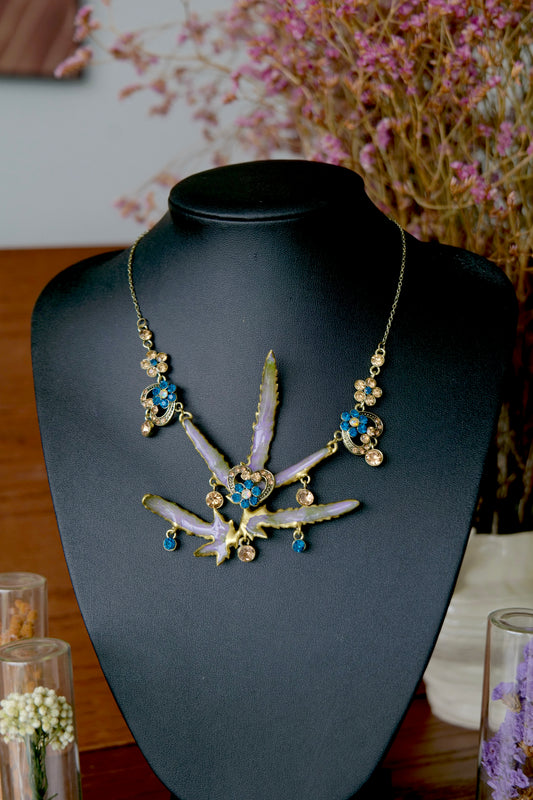 Handmade Lygodium japonicum leaf statement necklace with layered preserved botanical forms and blue crystals.