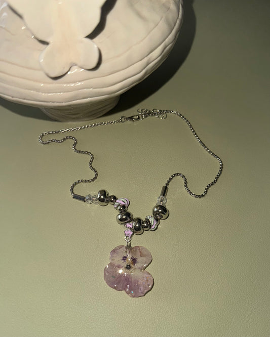 Smoky-pink pansy beaded necklace with silver-toned rounded beads shown from the front