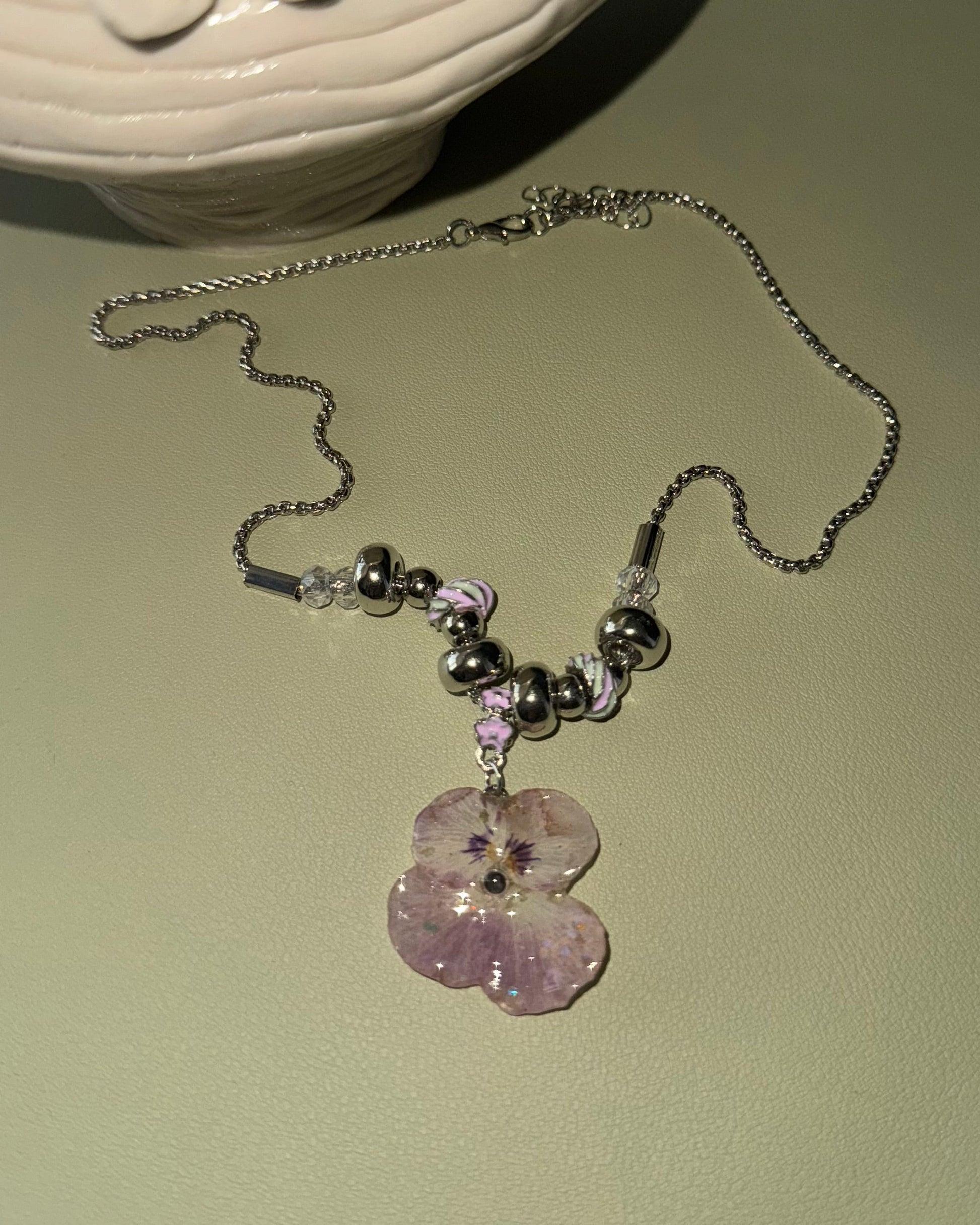 Alternate flat view of smoky-pink pansy necklace and silver-toned beads
