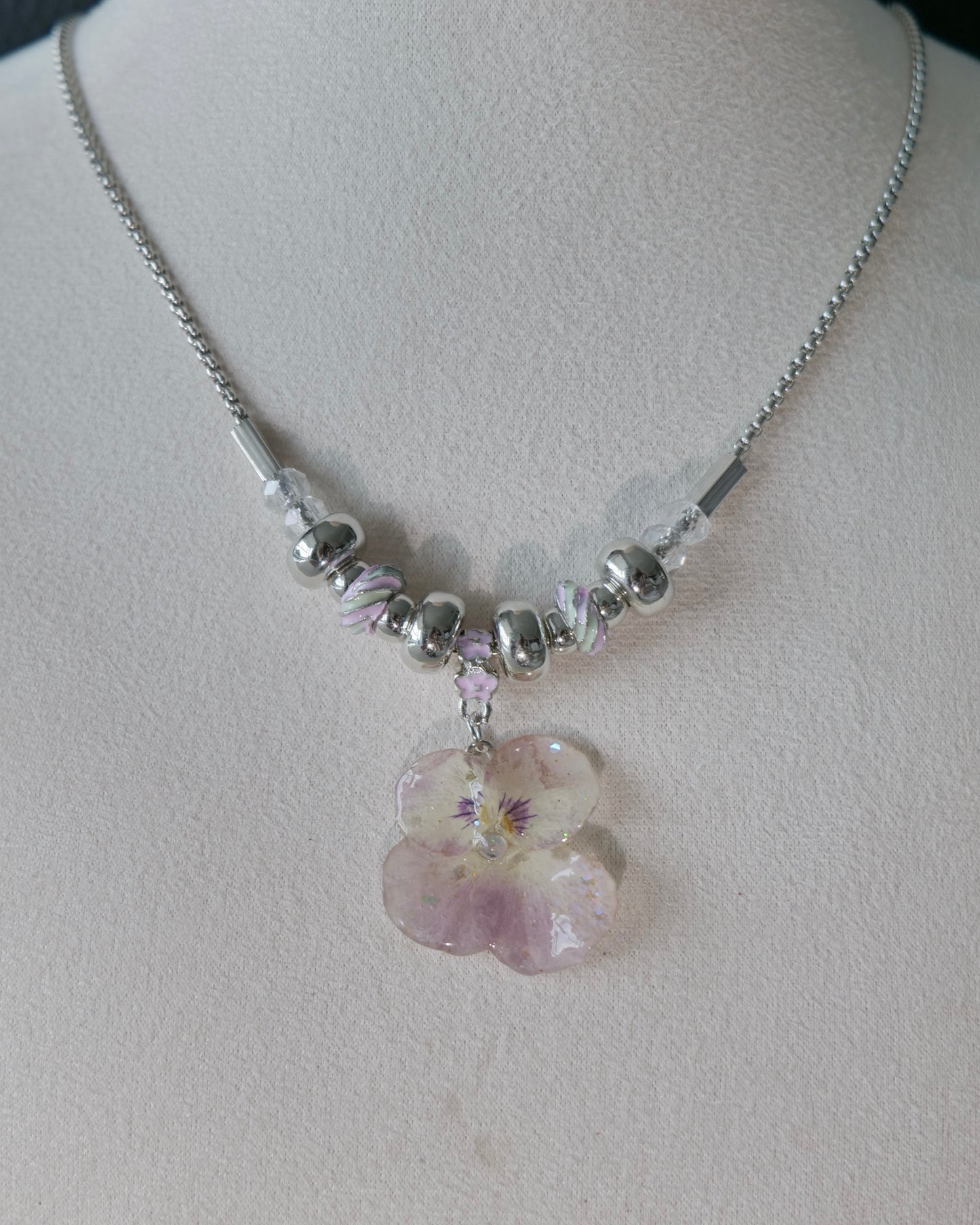 Natural-light angle of pansy necklace with pink-lilac swirl beads