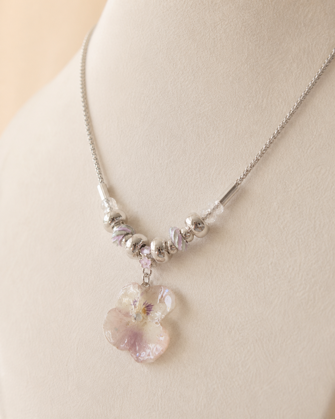 Close view of the real smoky-pink pansy preserved in clear resin, Smoky Pink Pansy Beaded Necklace botanical jewellery by Terra Decode