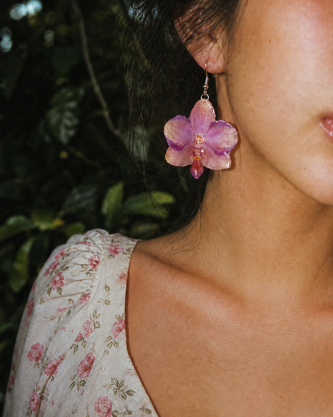 Close-up of a sunset-pink Phalaenopsis orchid earring worn with a floral dress, Sunset Pink Phalaenopsis Drop Earrings botanical jewellery by Terra Decode