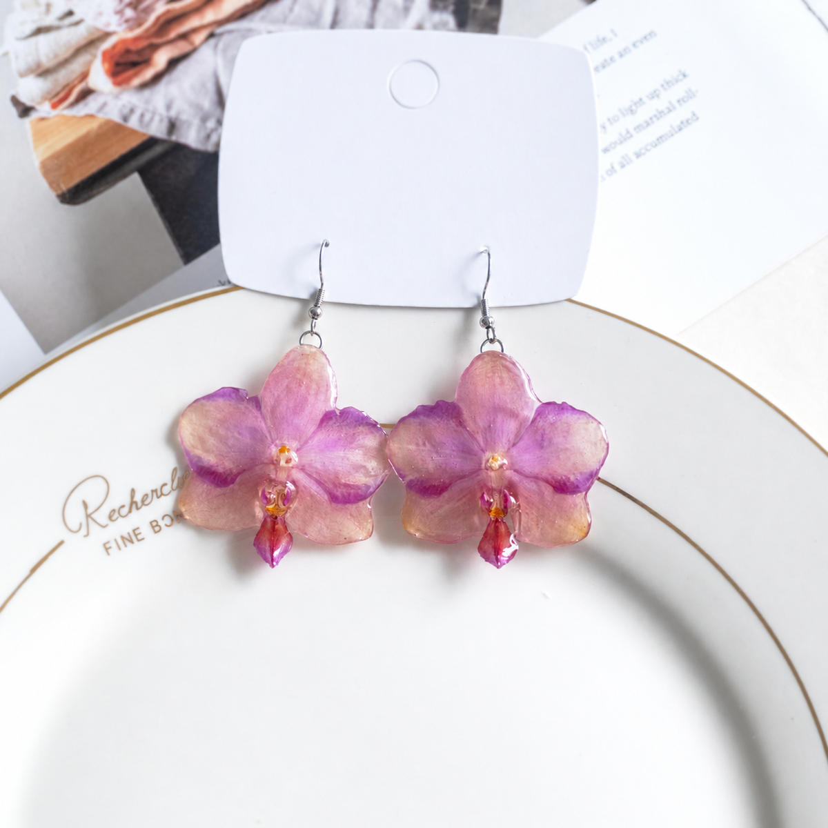 Front view of pink-purple orchid earrings with translucent resin petals and silver-tone hooks, Sunset Pink Phalaenopsis Drop Earrings botanical jewellery by Terra Decode