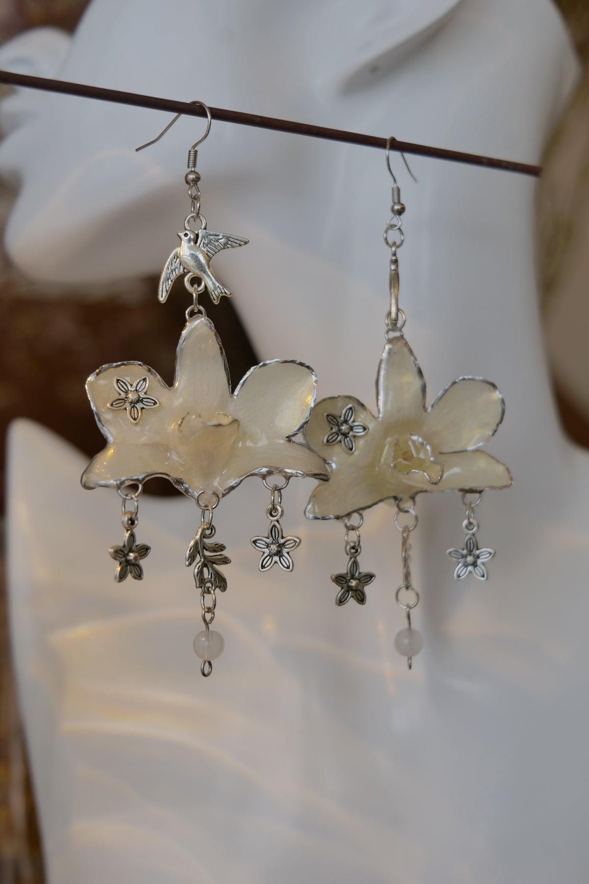AURORA — White Dendrobium Flower & Bird Dangle Earrings by Terra Decode — product photograph 4 showing the handmade botanical earrings.