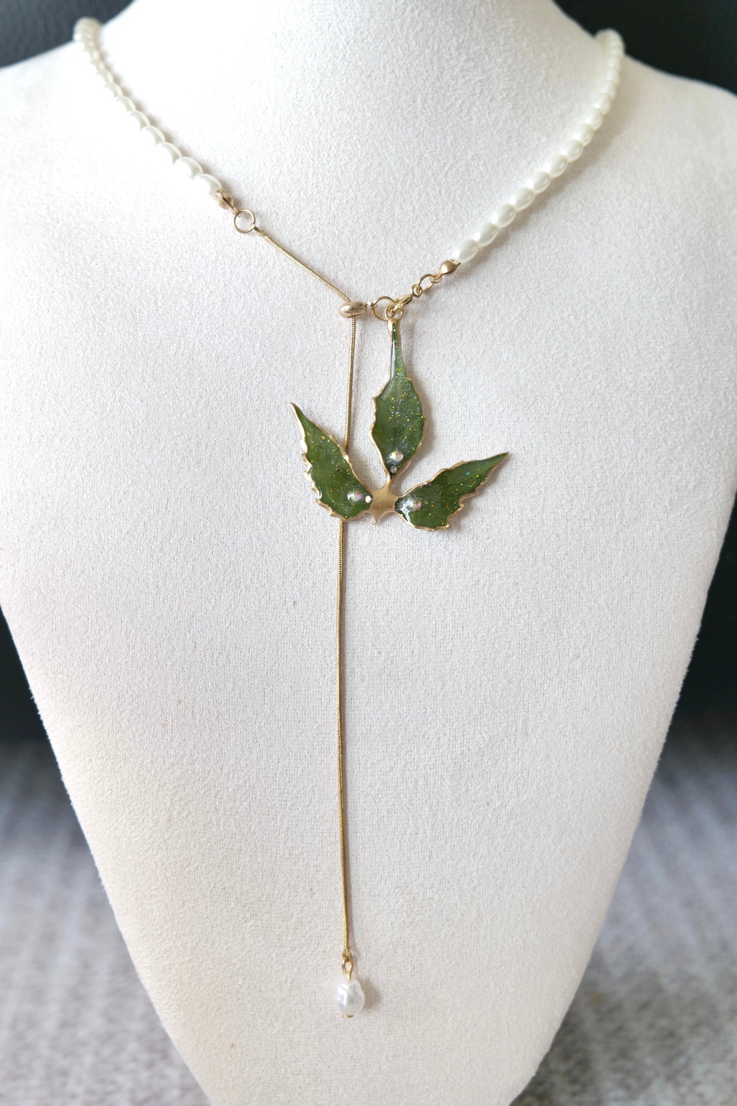 Angled view of the Boston ivy pendant and asymmetric imitation-pearl half-chain