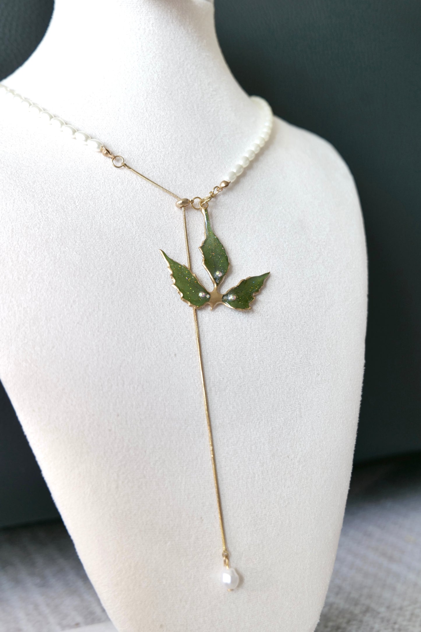Close-up of Boston ivy leaf veins, gold-toned details and three crystal-style accents