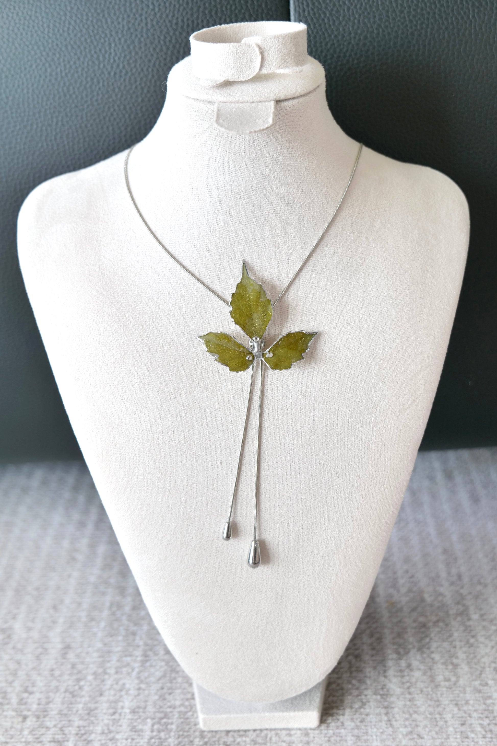 Left angled view of the silver three-leaf twin-drop lariat necklace by Terra Decode