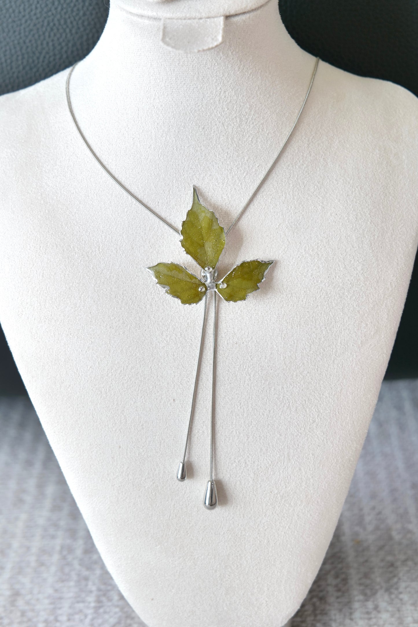 Right angled view of the silver three-leaf twin-drop lariat necklace by Terra Decode