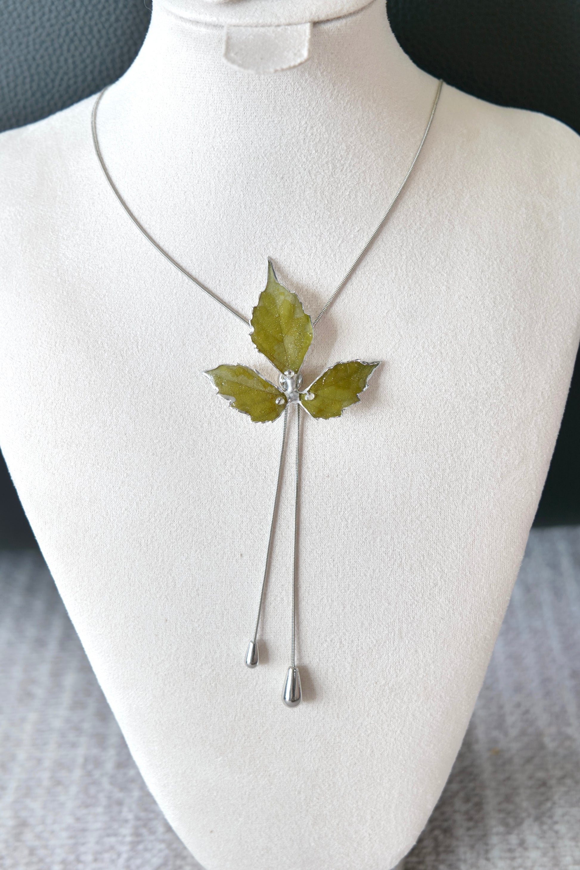 Right angled view of the silver three-leaf twin-drop lariat necklace by Terra Decode