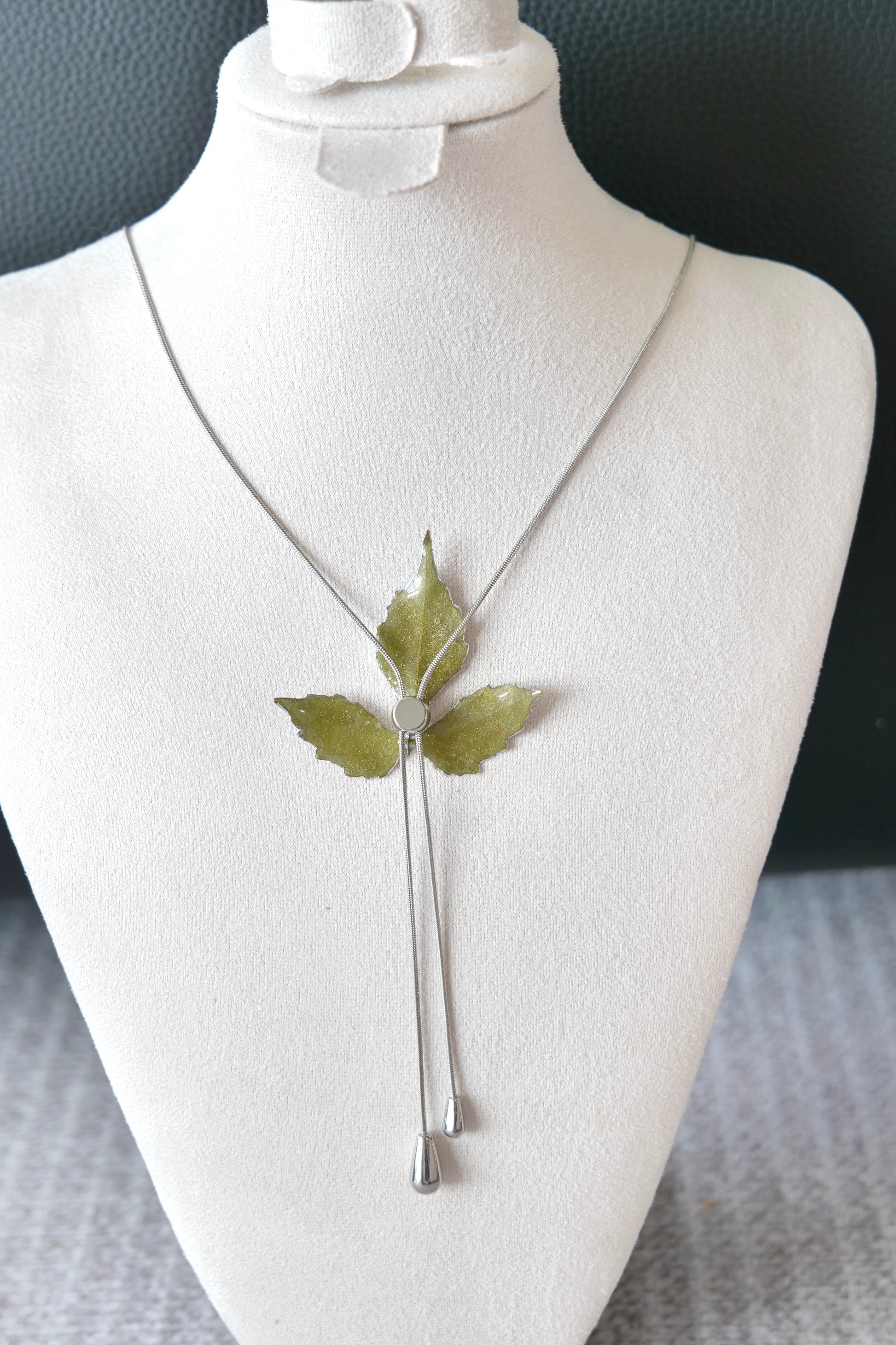 Side view of the silver three-leaf twin-drop lariat necklace by Terra Decode