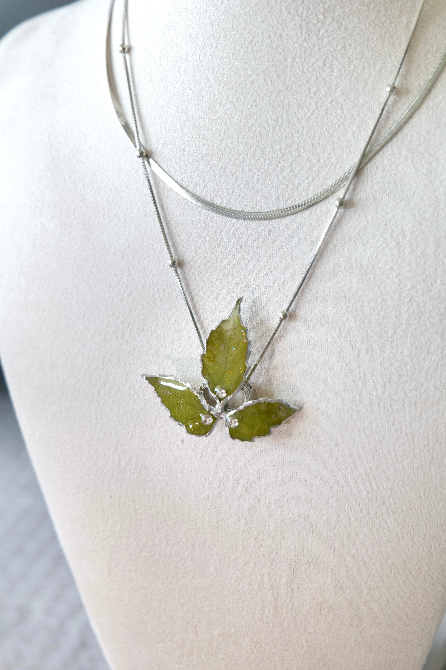 Pendant close-up of the layered silver three-leaf botanical necklace by Terra Decode