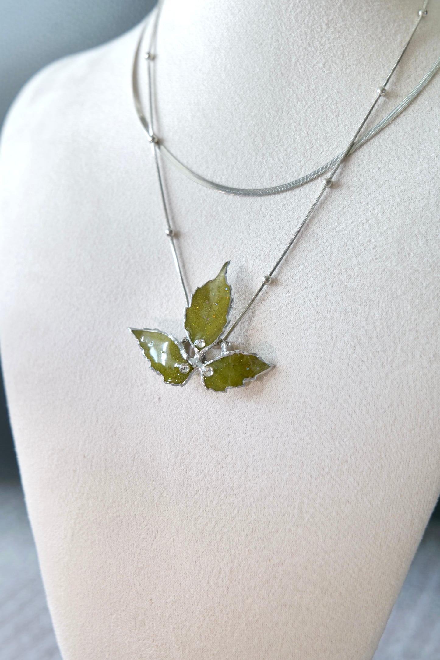 Full-length alternative view of the layered silver three-leaf botanical necklace by Terra Decode