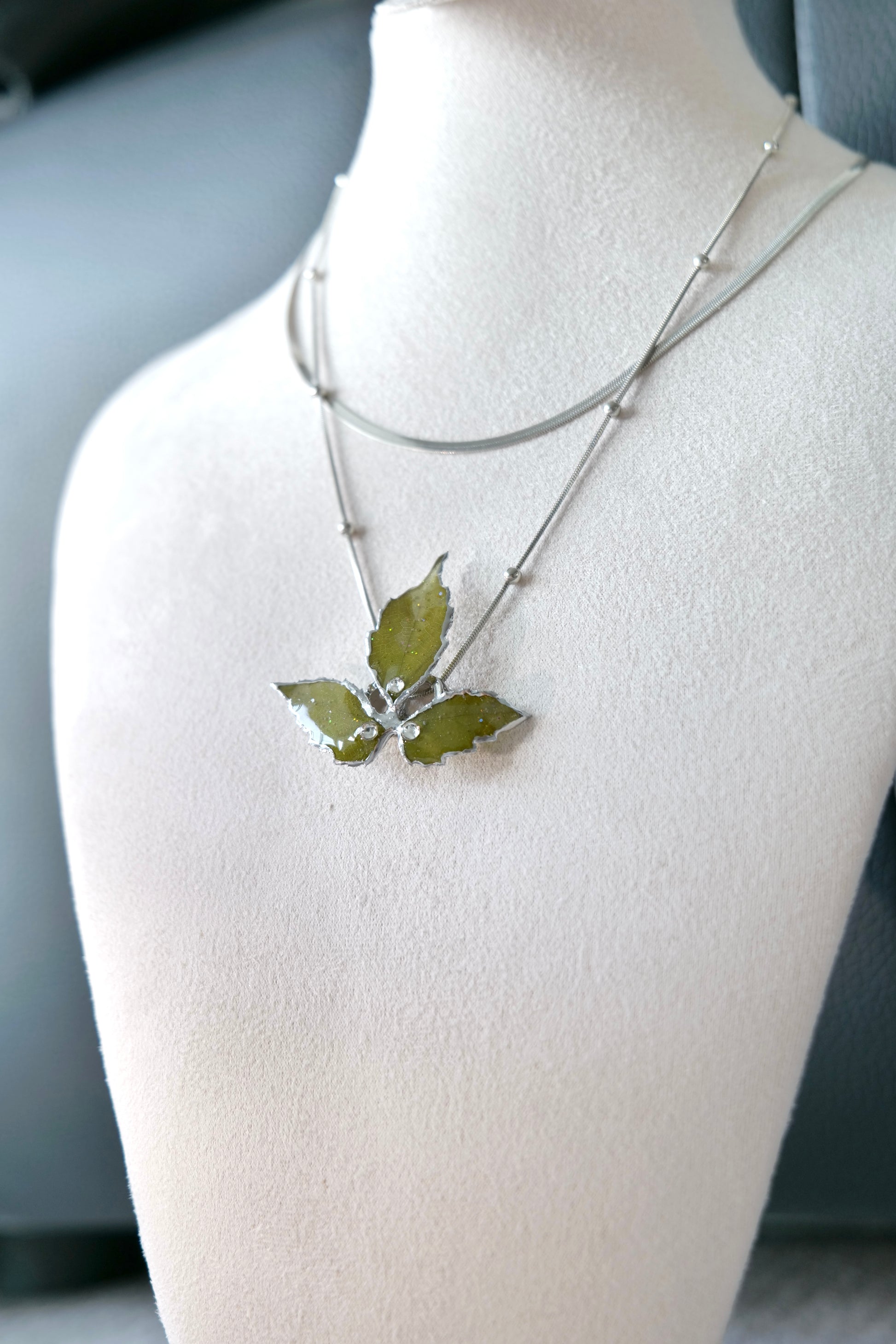 Lower chain and clear-resin Boston ivy pendant detail