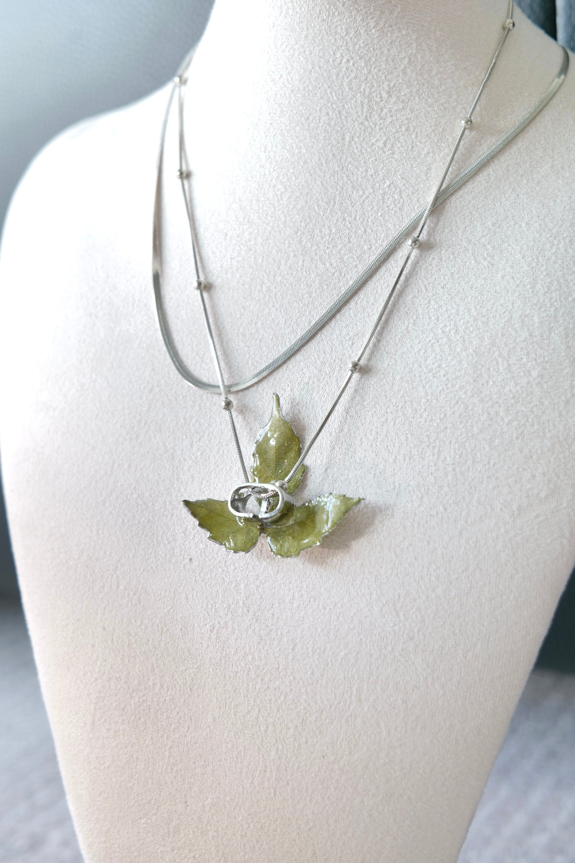 Side view of the layered silver three-leaf botanical necklace by Terra Decode