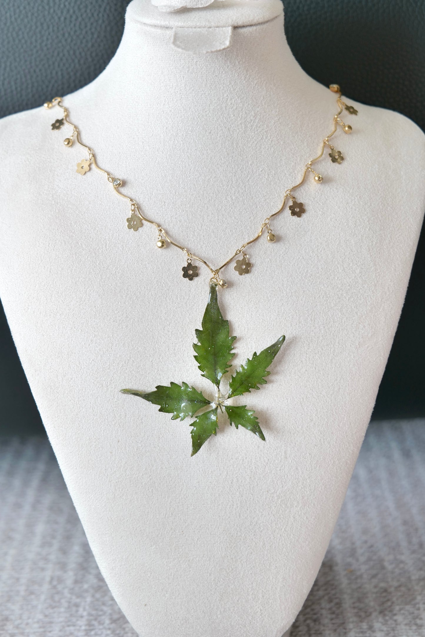 Front view of radiating Chinese chaste tree leaflets and floral metal charms