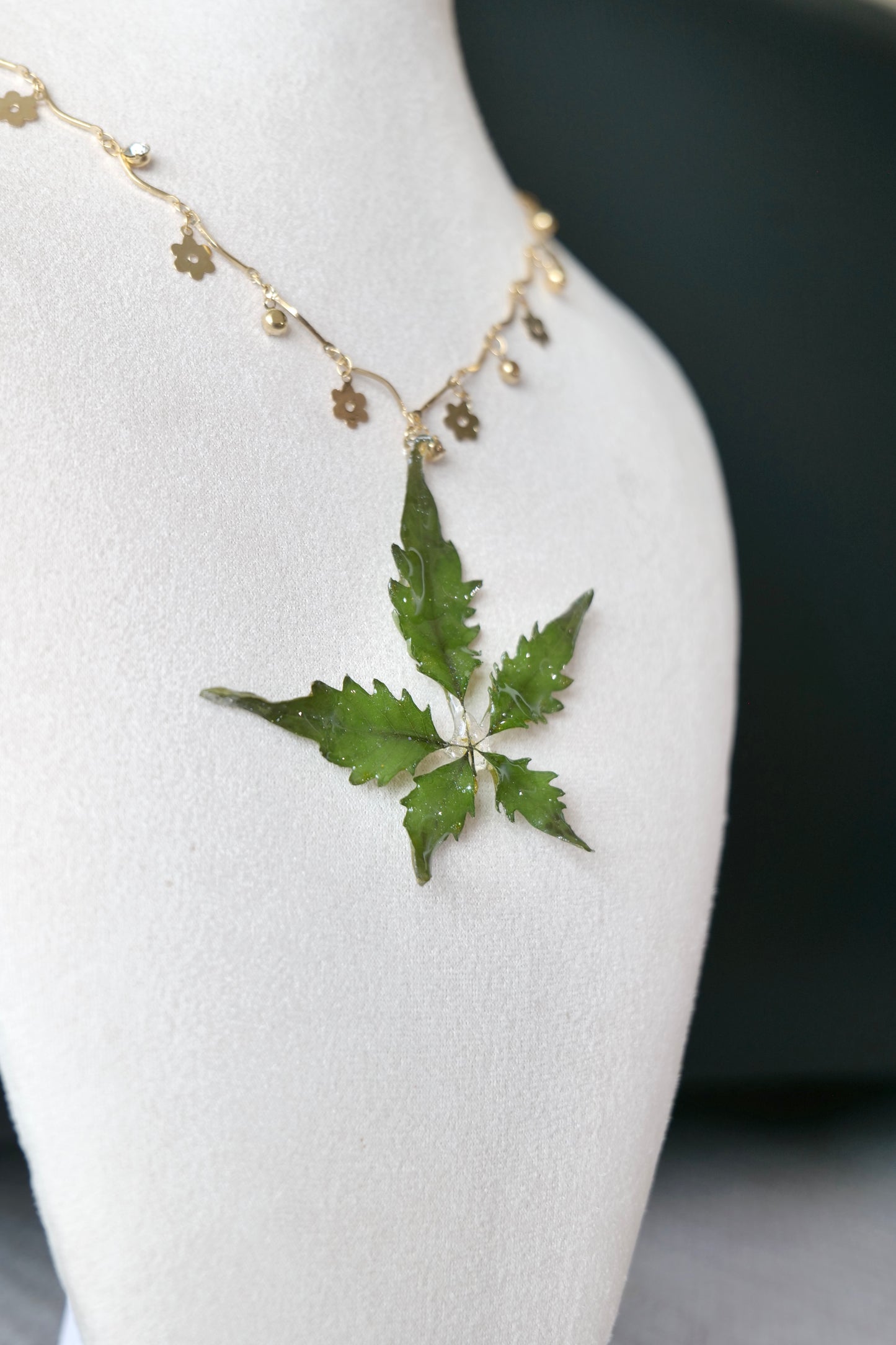 Full-length alternative view of the serrated five-leaf floral-charm necklace by Terra Decode