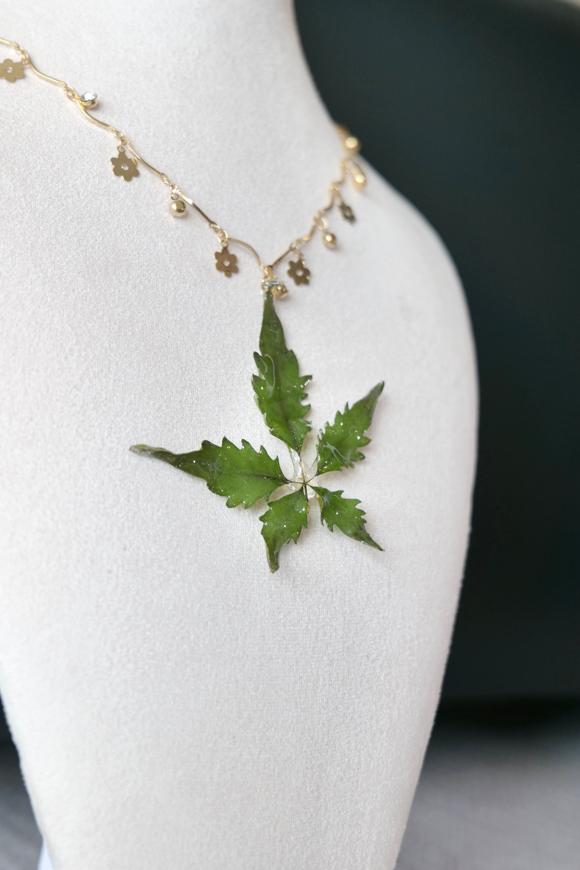 Full-length alternative view of the serrated five-leaf floral-charm necklace by Terra Decode