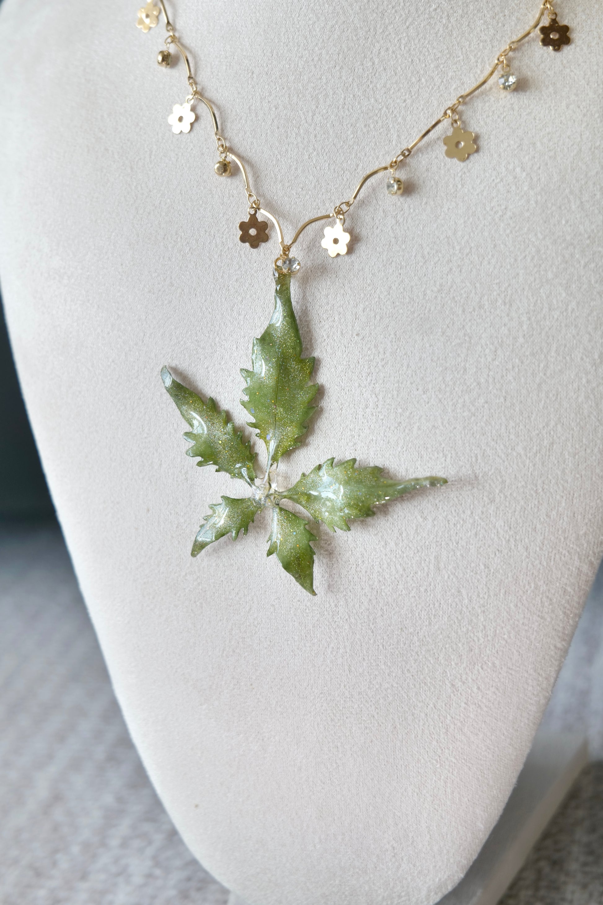 Necklace profile view of the serrated five-leaf floral-charm necklace by Terra Decode