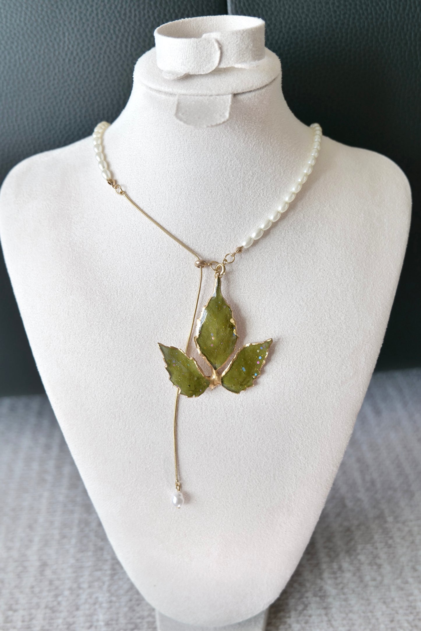 Front view of gold-edged Boston ivy leaves and asymmetric pearl half-chain