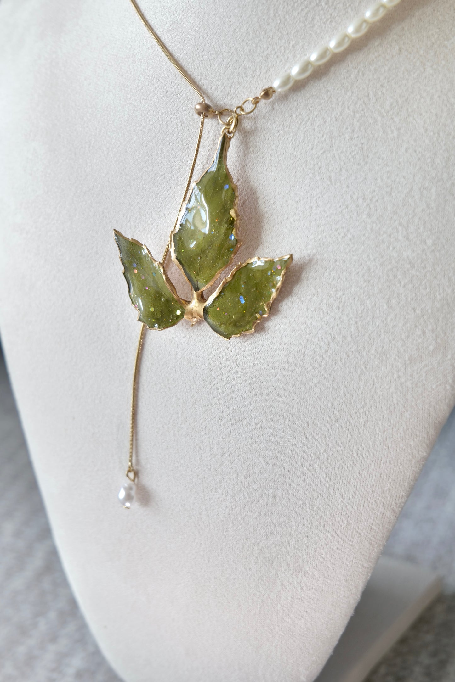 Full-length alternative view of the gold-edged broad three-leaf pearl-drop necklace by Terra Decode