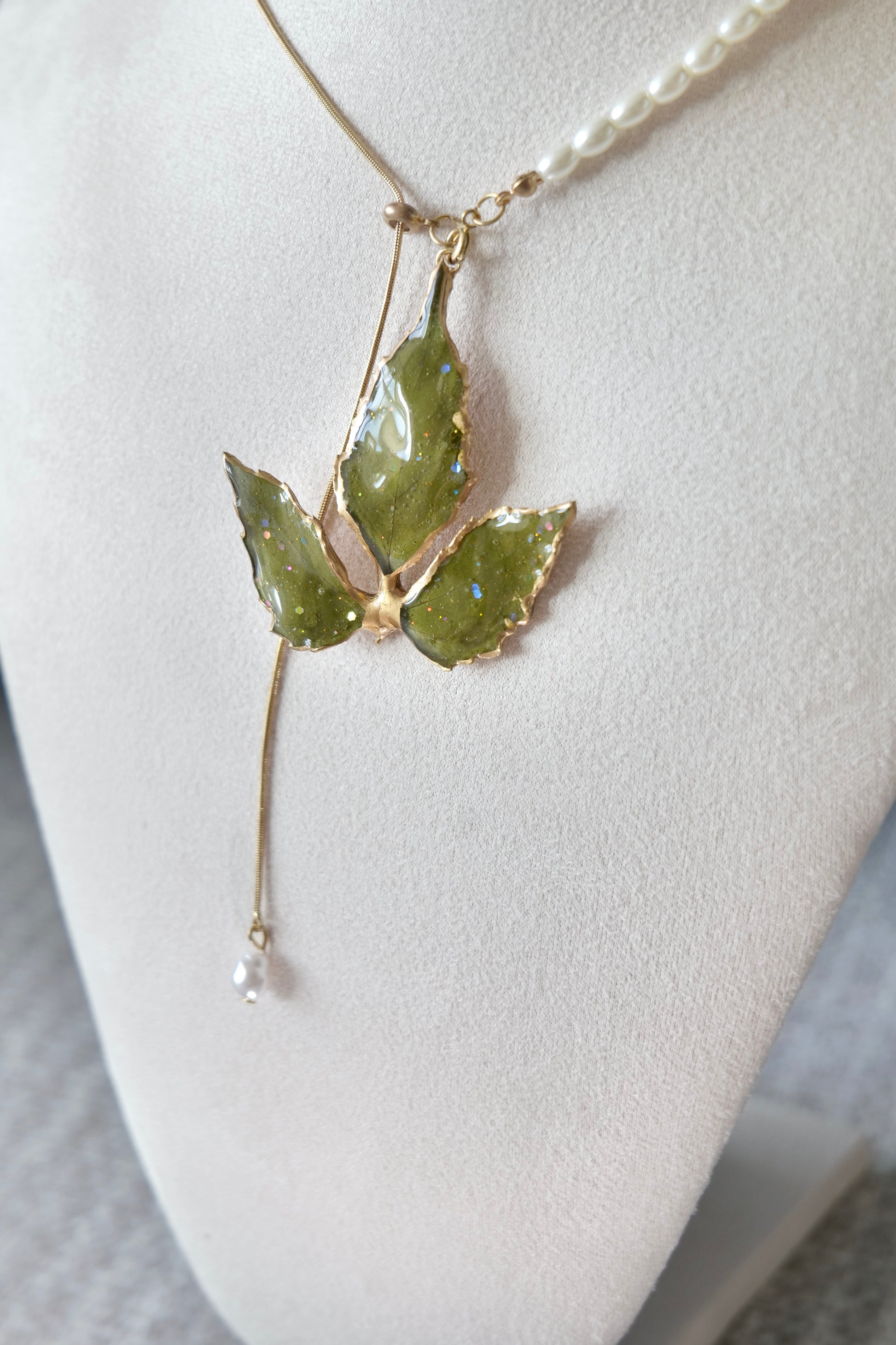 Full-length alternative view of the gold-edged broad three-leaf pearl-drop necklace by Terra Decode
