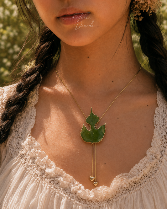 Paper mulberry pendant on a gold-toned lariat with two heart-shaped terminal drops by Terra Decode
