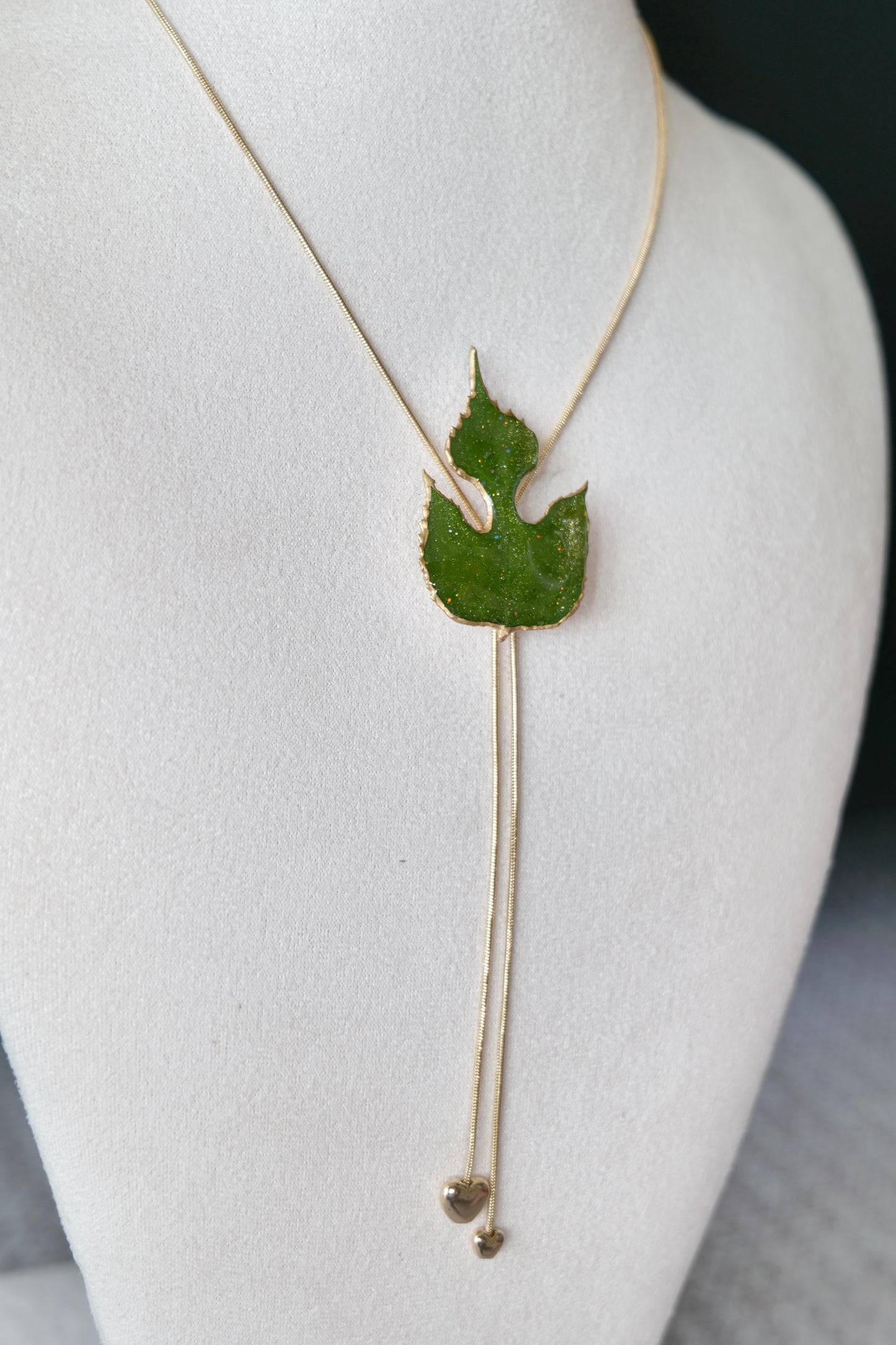 Right angled view of the sculptural green leaf double-heart lariat necklace by Terra Decode