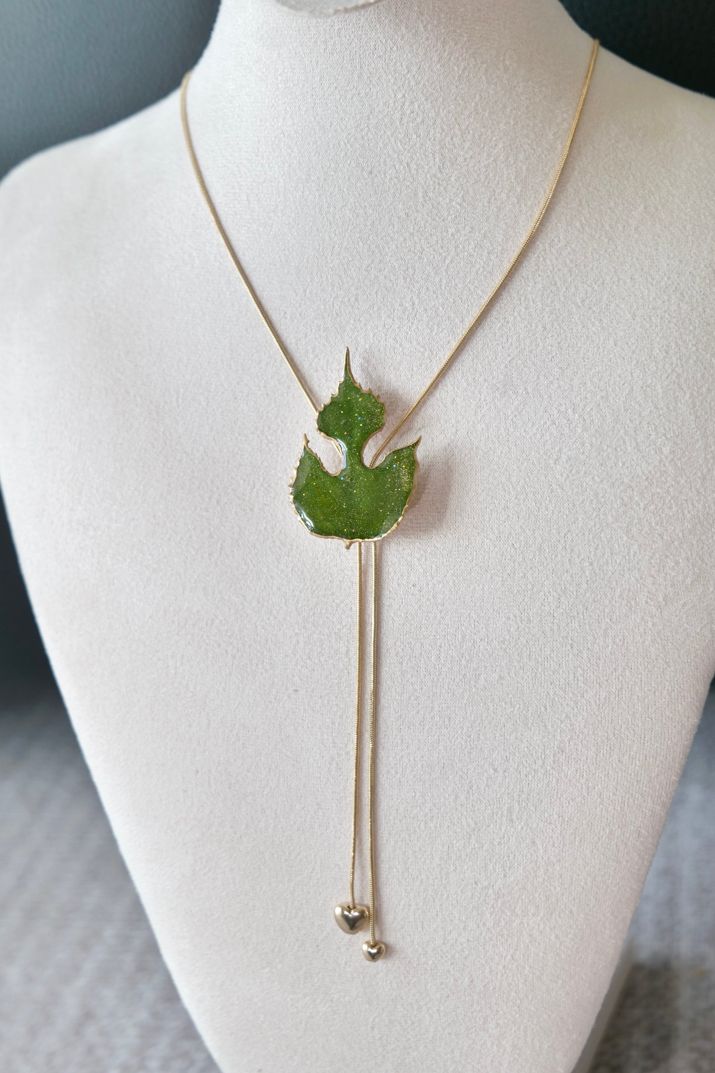 Close-up of the clear-resin paper mulberry botanical pendant