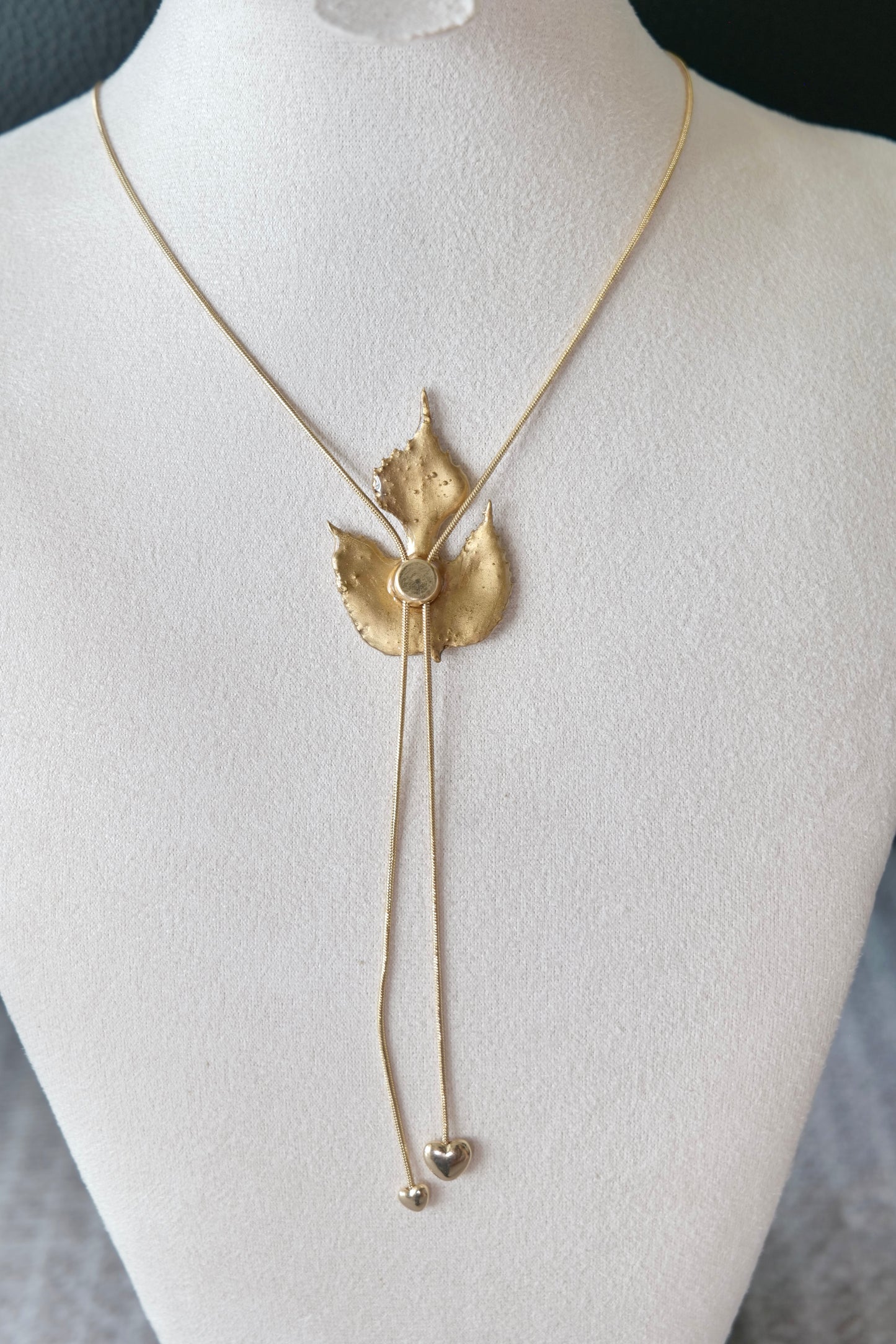 Necklace profile view of the sculptural green leaf double-heart lariat necklace by Terra Decode