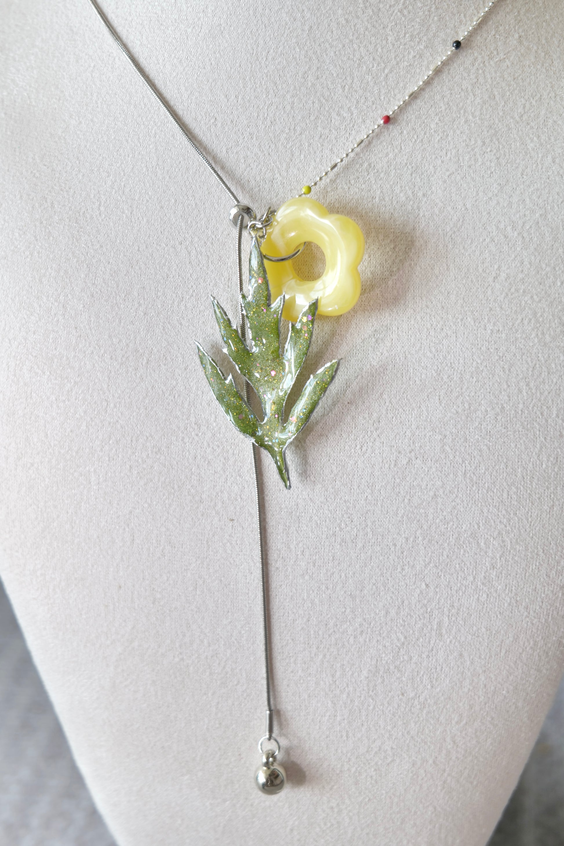 Silver-toned alloy metal drop detail below the Chinese mugwort pendant