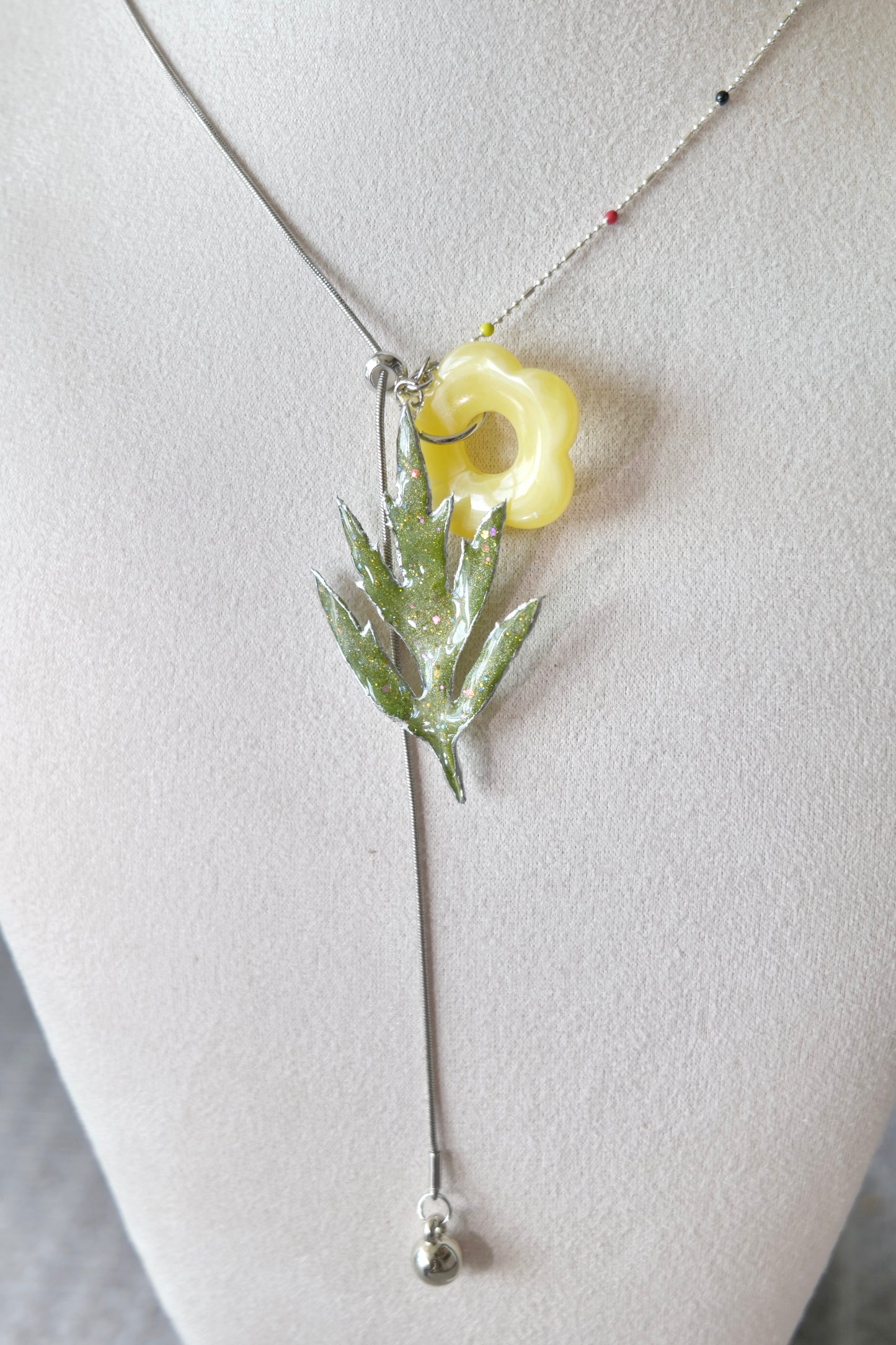 Side view of the Chinese mugwort pendant and yellow acrylic flower charm