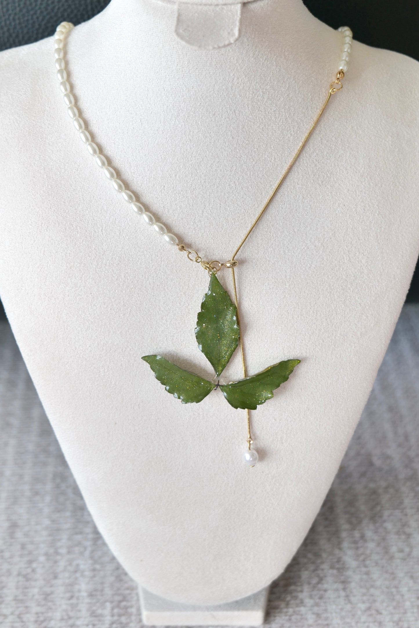Front view of the Boston ivy necklace and imitation-pearl half-chain