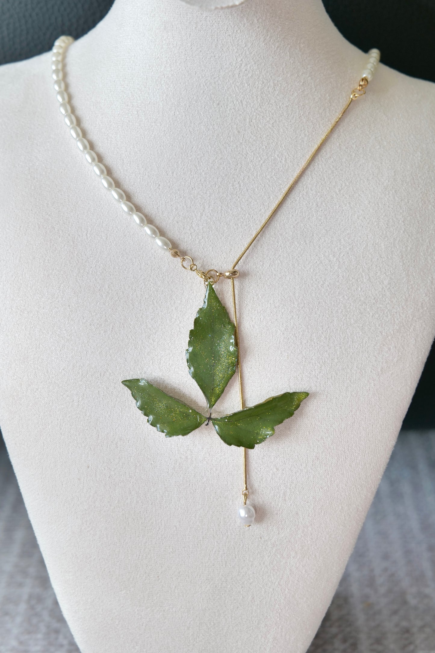 Necklace profile view of the minimal olive three-leaf pearl-drop necklace by Terra Decode