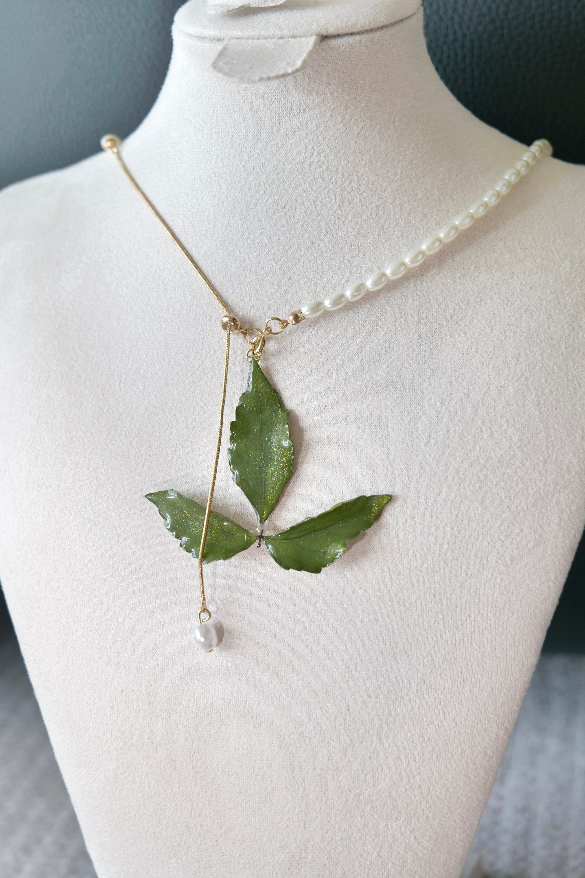Fine detail of the clear-resin Boston ivy pendant and pearl drop