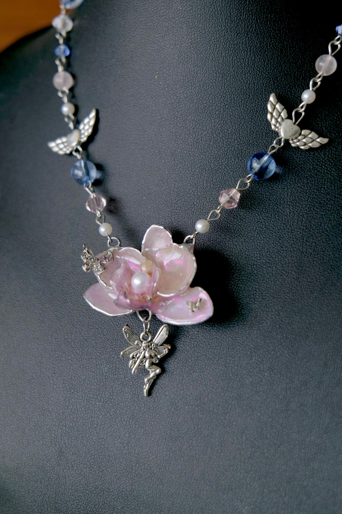 Handmade Y2K necklace with preserved pink orchid, silver angel charms and pastel glass beads.