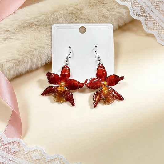 Crimson orchid earrings with resin petals on a jewellery card by Terra Decode