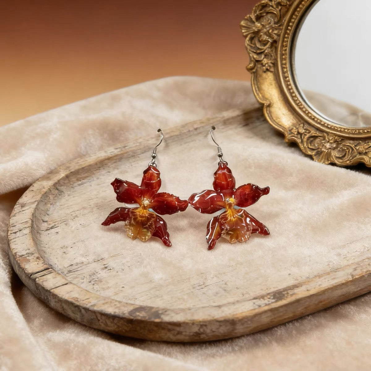 Crimson orchid drop earrings with resin petals on a velvet tray by Terra Decode