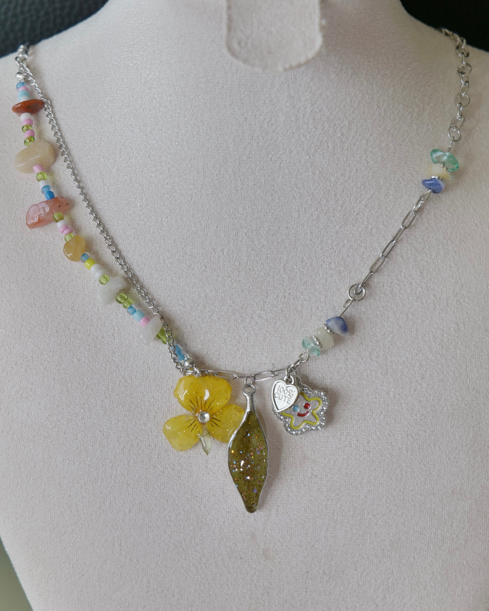 Natural-light view of pansy and nandina necklace with mixed silver-toned chain