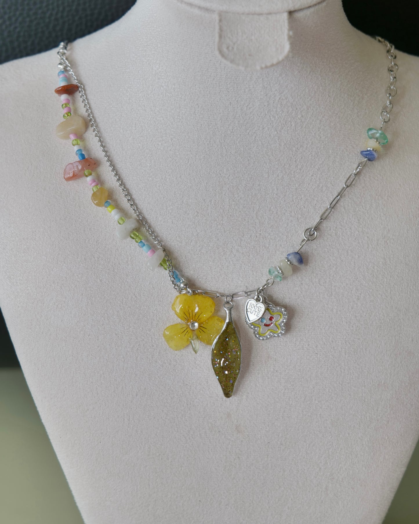 Angled view of the Yellow Pansy and Nandina Leaf Y2K Charm Necklace showing stone chips