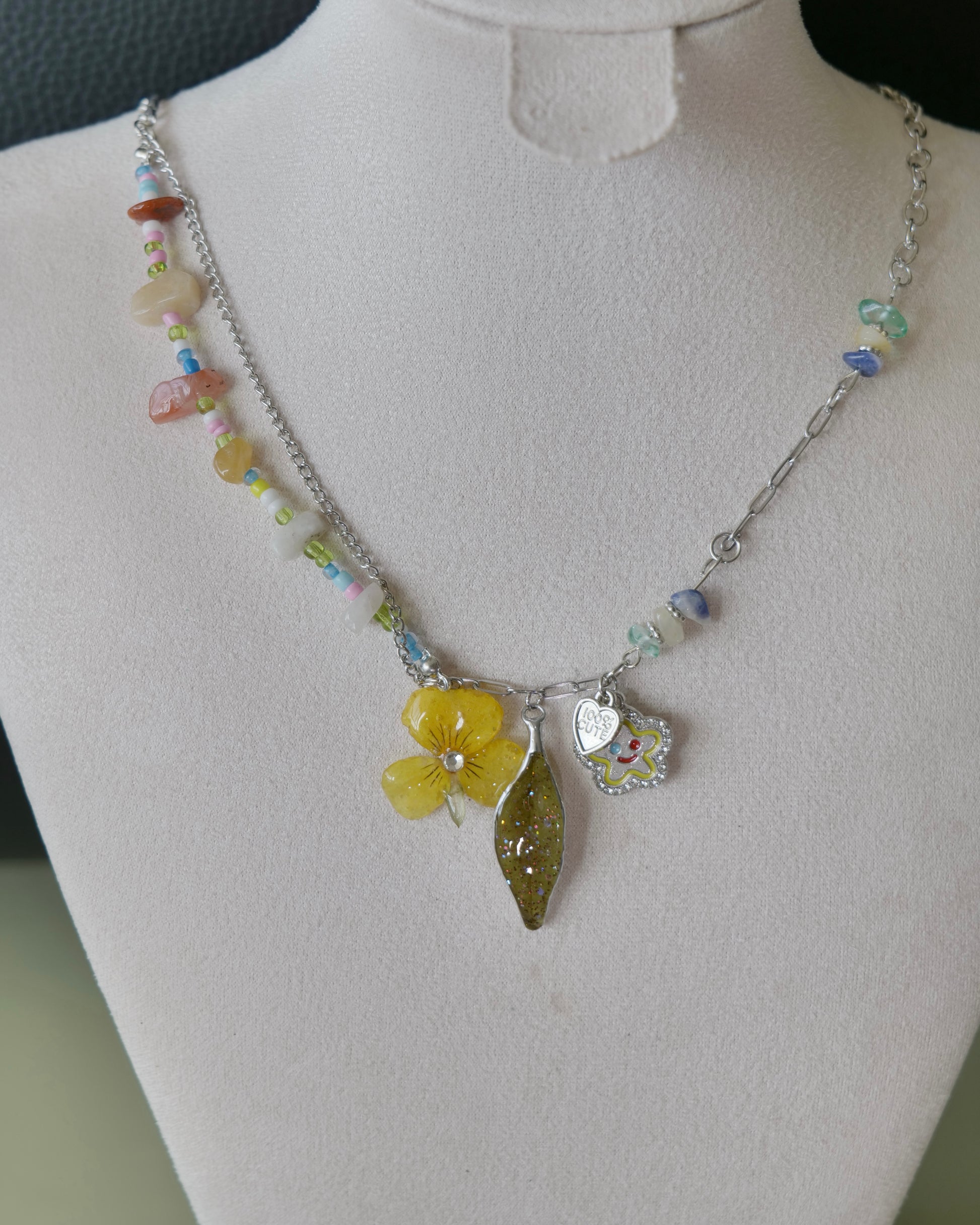 Angled view of the Yellow Pansy and Nandina Leaf Y2K Charm Necklace showing stone chips