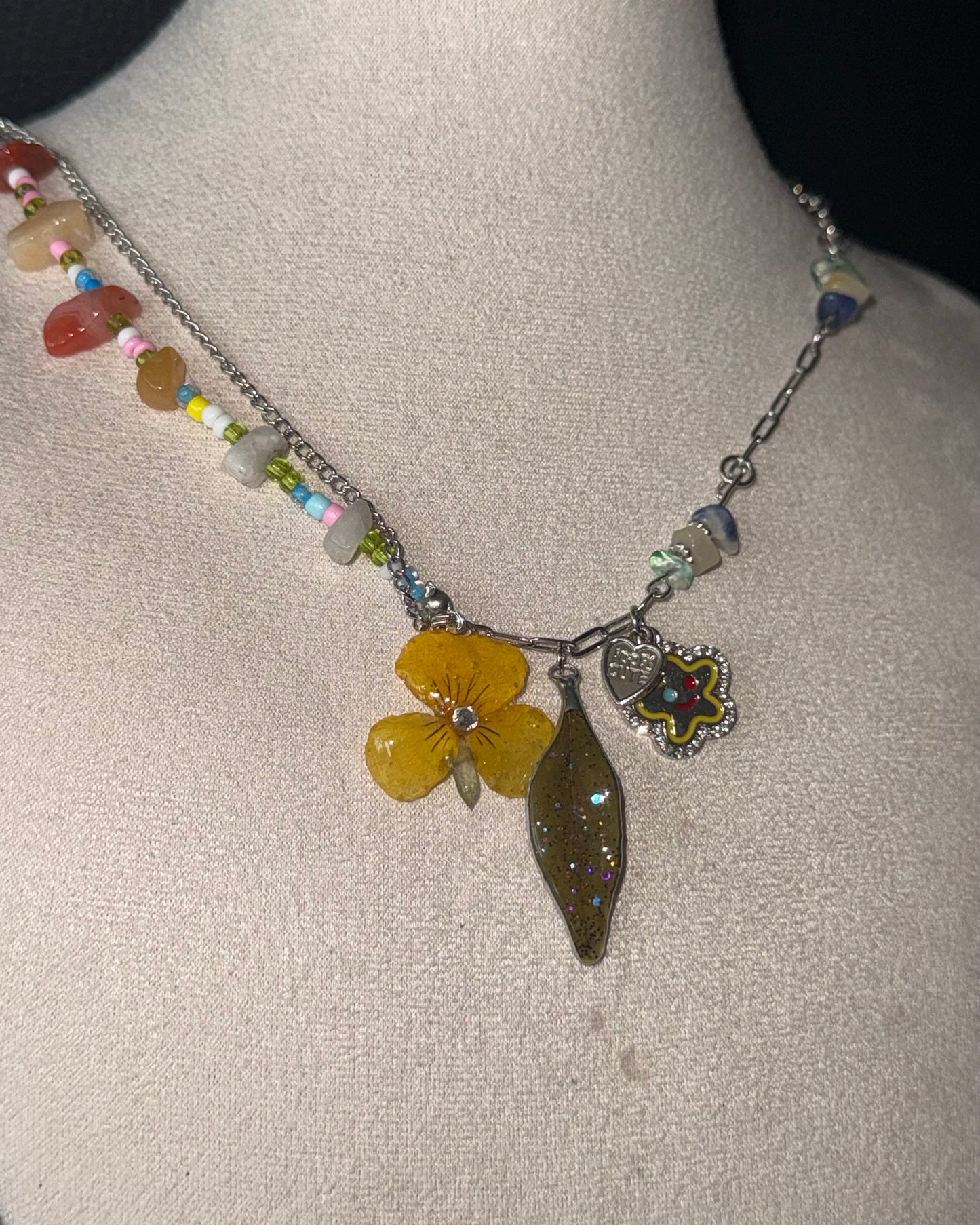 Reflective full view of pansy and Nandina necklace with colourful beads