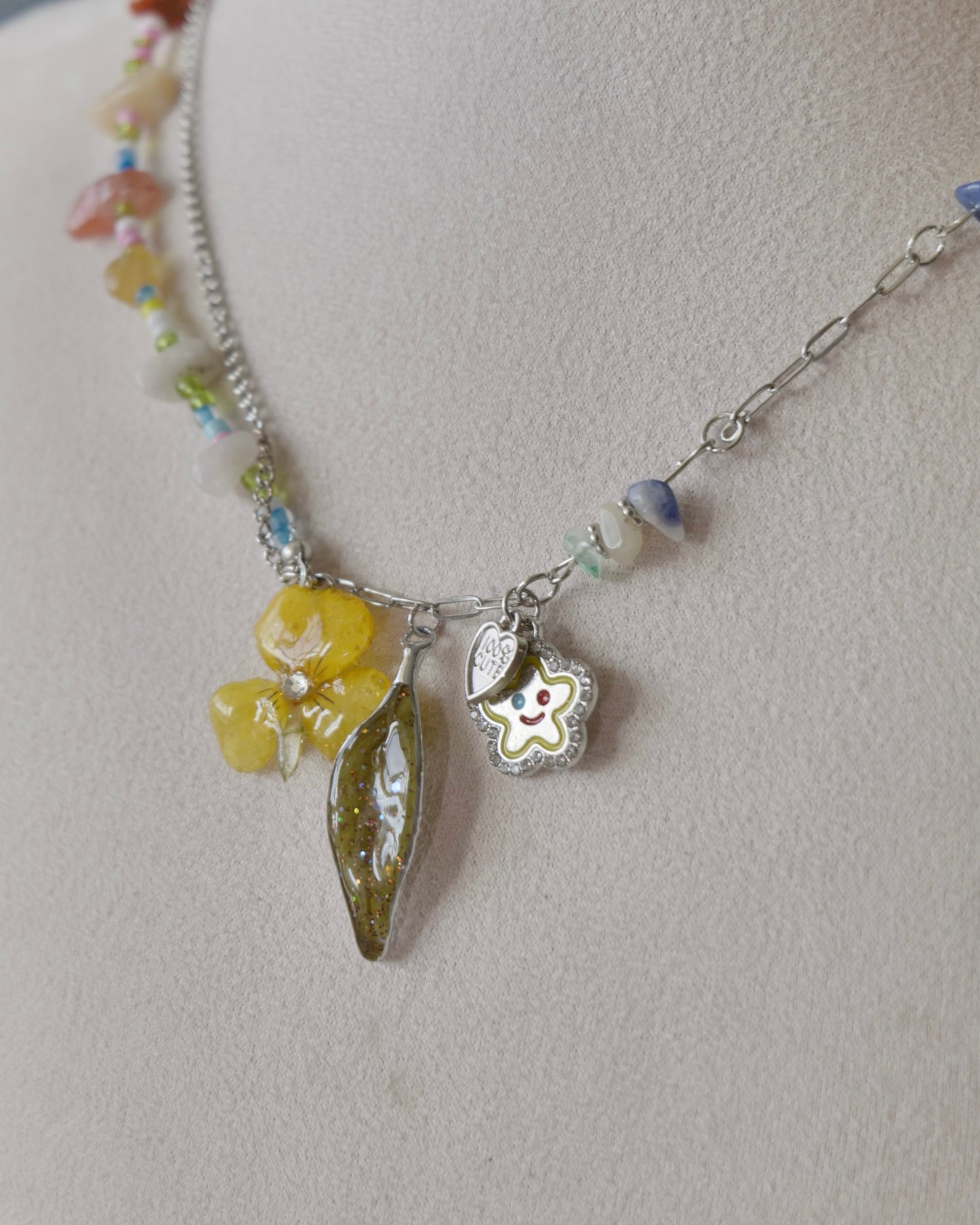 Side angle showing natural-stone chips and mixed silver-toned chain