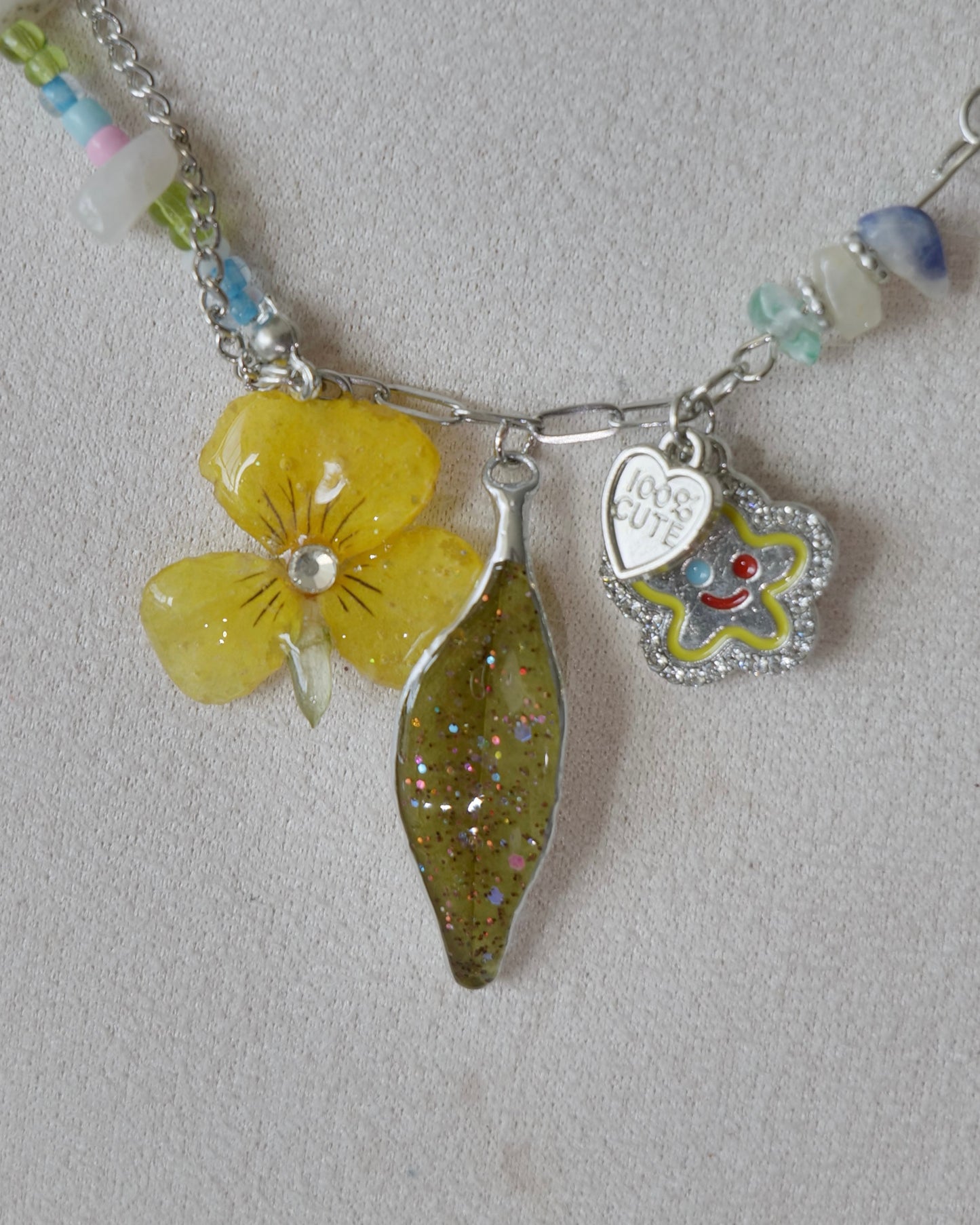 Detailed view of preserved botanical pendants and playful flower charm