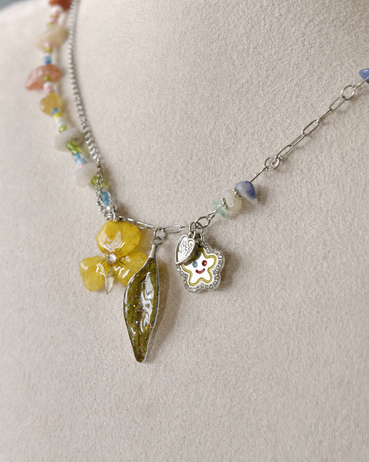 Close view of the real pansy and Nandina leaf pendants preserved in clear resin, Yellow Pansy & Nandina Leaf Y2K Charm Necklace botanical jewellery by Terra Decode