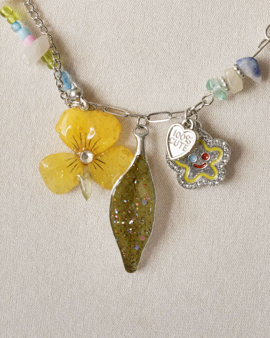Full display view showing the playful charms and beaded sections of the necklace, Yellow Pansy & Nandina Leaf Y2K Charm Necklace botanical jewellery by Terra Decode