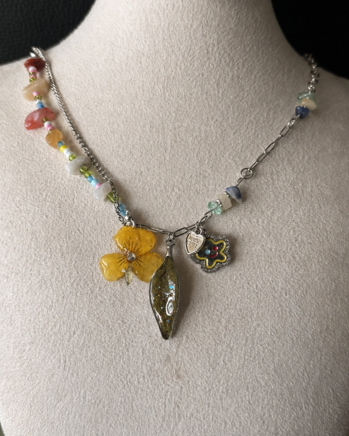 Alternate angle of the yellow pansy pendant, green Nandina leaf and heart charm, Yellow Pansy & Nandina Leaf Y2K Charm Necklace botanical jewellery by Terra Decode